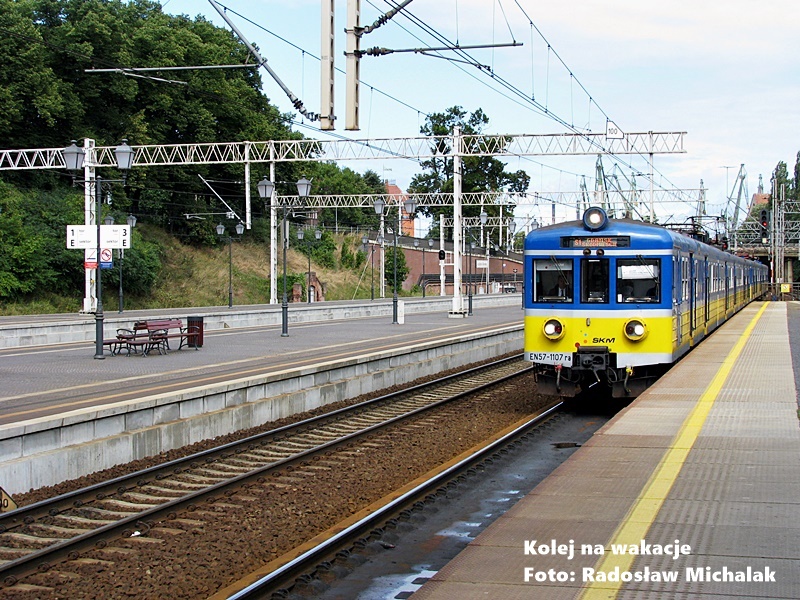Klasyczny żółto-niebieski pociąg elektryczny SKM serii EN57 na trasie wiodącej przez Trójmiasto.
