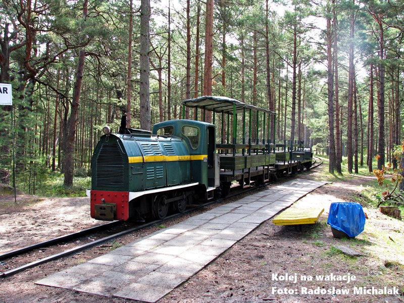 Mała lokomotywa spalinowa z otwartymi wagonikami pasażerskimi Kolei Rejonu Umocnionego Hel