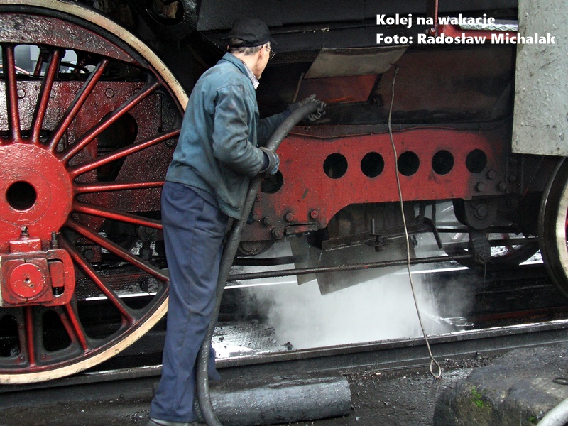Przygotowanie parowozu do trasy w Parowozowni Wolsztyn. Mechanik wykonujący przegląd techniczny lokomotywy parowej przed wyjazdem na szlak.