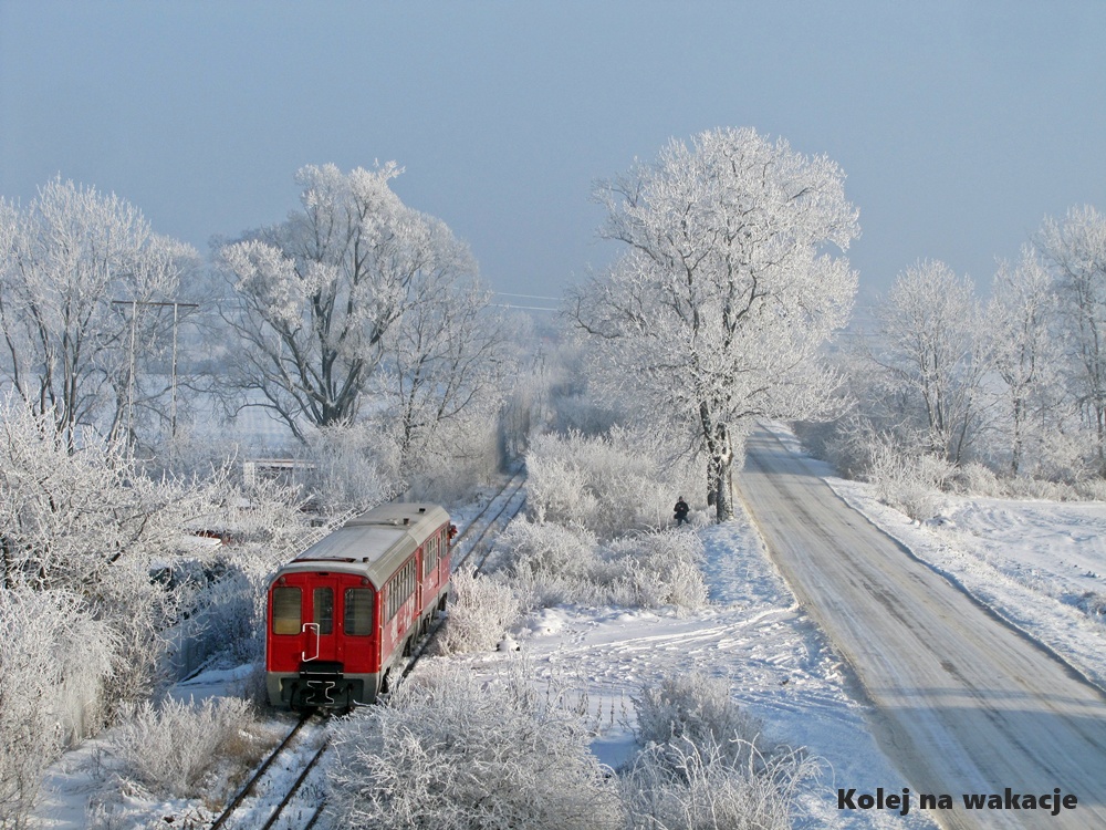 Sceniczny widok na zaśnieżone tory wąskotorowe w Pleszewie zimą. Ilustracja magicznego klimatu podróży.