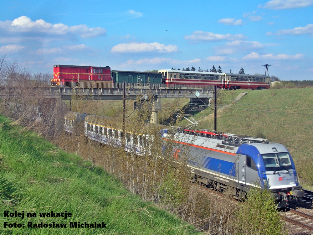 Wyjątkowe skrzyżowanie w Pągowie: Na wiadukcie stoi pociąg Kolei Wąskotorowej Rogów – Rawa – Biała, a bezpośrednio pod nim, na torach Centralnej Magistrali Kolejowej (CMK), pędzi szybki skład normalnotorowy.