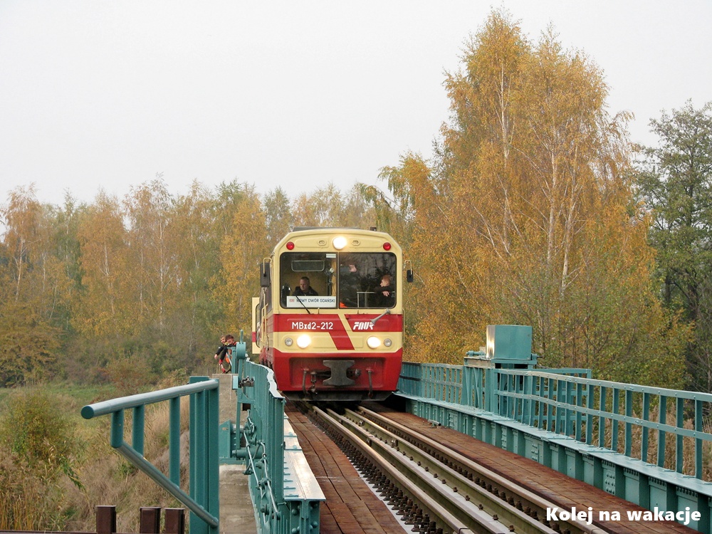 Wagon motorowy MBxd2-212 Żuławskiej Kolei Dojazdowej na moście obrotowym w Rybinie; jesienny klimat nad rzeką Szkarpawą.