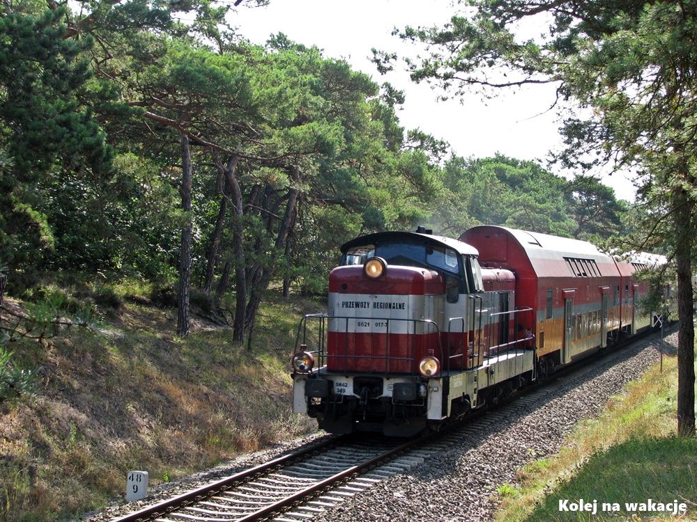 Pociąg na linii kolejowej Puck – Hel między Jastarnią a Juratą, prowadzony przez lokomotywę SM42-349, w otoczeniu nadmorskich krajobrazów.