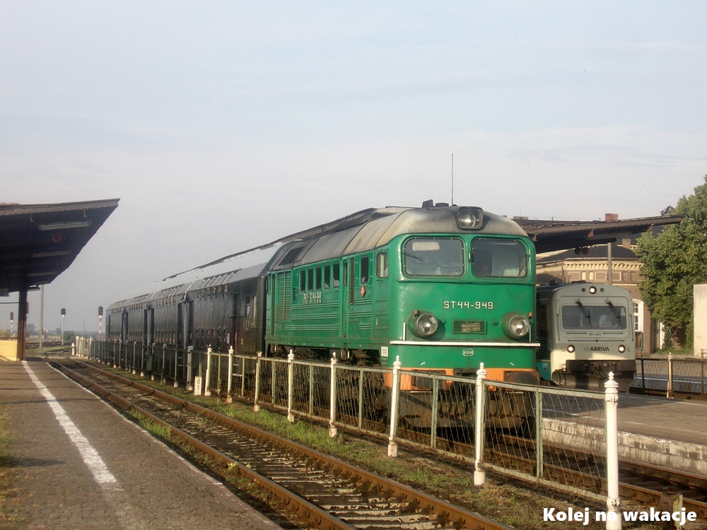 Stacja kolejowa w Chojnicach w lipcu 2010 roku. Na peronach stoją obok siebie lokomotywa ST44-949 ze składem wagonów piętrowych Bipa oraz duński wagon motorowy MR4001 w barwach Arrivy.
