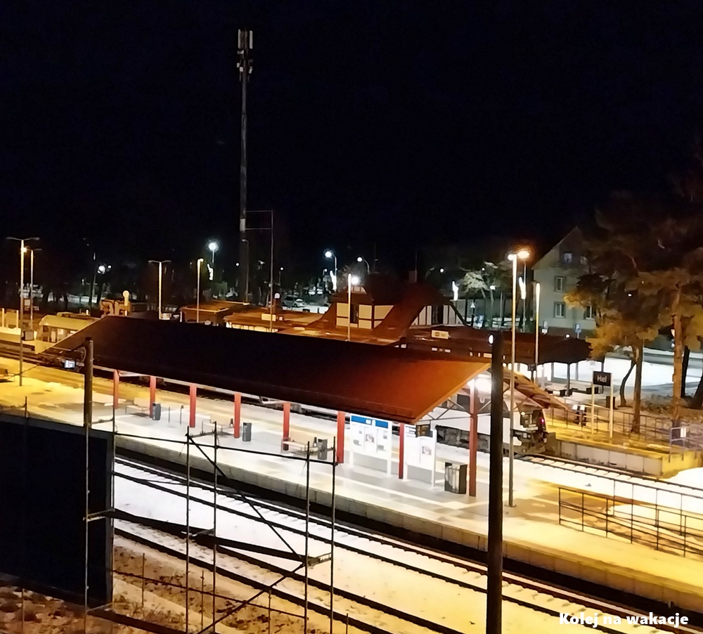 Stacja Hel zimą o zmierzchu, widok na perony i pociągi kończące trasę Puck – Hel.