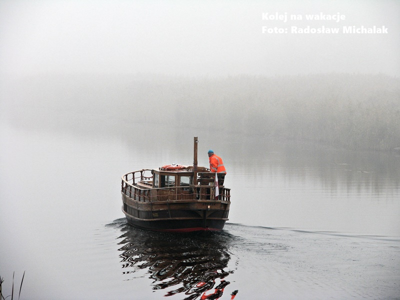 Żuławy i Mierzeja Wiślana: unikalny region Polski - łódź płynąca przez gęstą mgłę na rzece Szkarpawa w okolicach Rybiny.