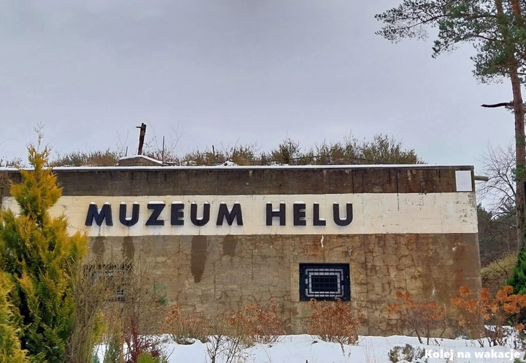 Wejście do Muzeum Obrony Wybrzeża w Helu mieszczącego się w betonowym schronie dawnej niemieckiej baterii artyleryjskiej „Schleswig-Holstein”. Nad wejściem widoczny jest wyraźny napis „Muzeum Helu”.
