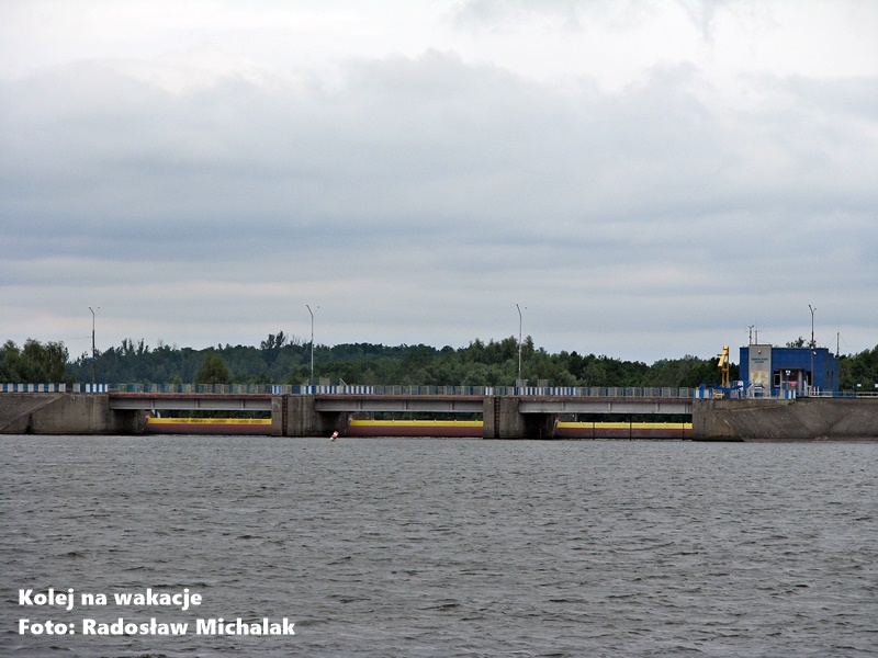 Widok na betonową zaporę wodną w Smardzewicach na Zalewie Sulejowskim. Monumentalna konstrukcja przecina rzekę Pilicę, oddzielając taflę zbiornika od koryta rzeki poniżej.