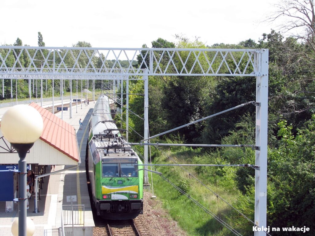 Widok z góry na lokomotywę EU47 i piętrowe wagony pociągu Słoneczny Kolei Mazowieckich przy peronie w Ustce.