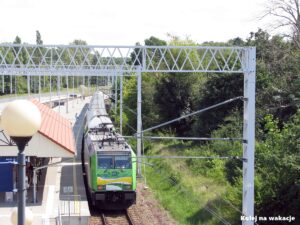 Widok z góry na lokomotywę EU47 i piętrowe wagony pociągu Słoneczny Kolei Mazowieckich przy peronie w Ustce.