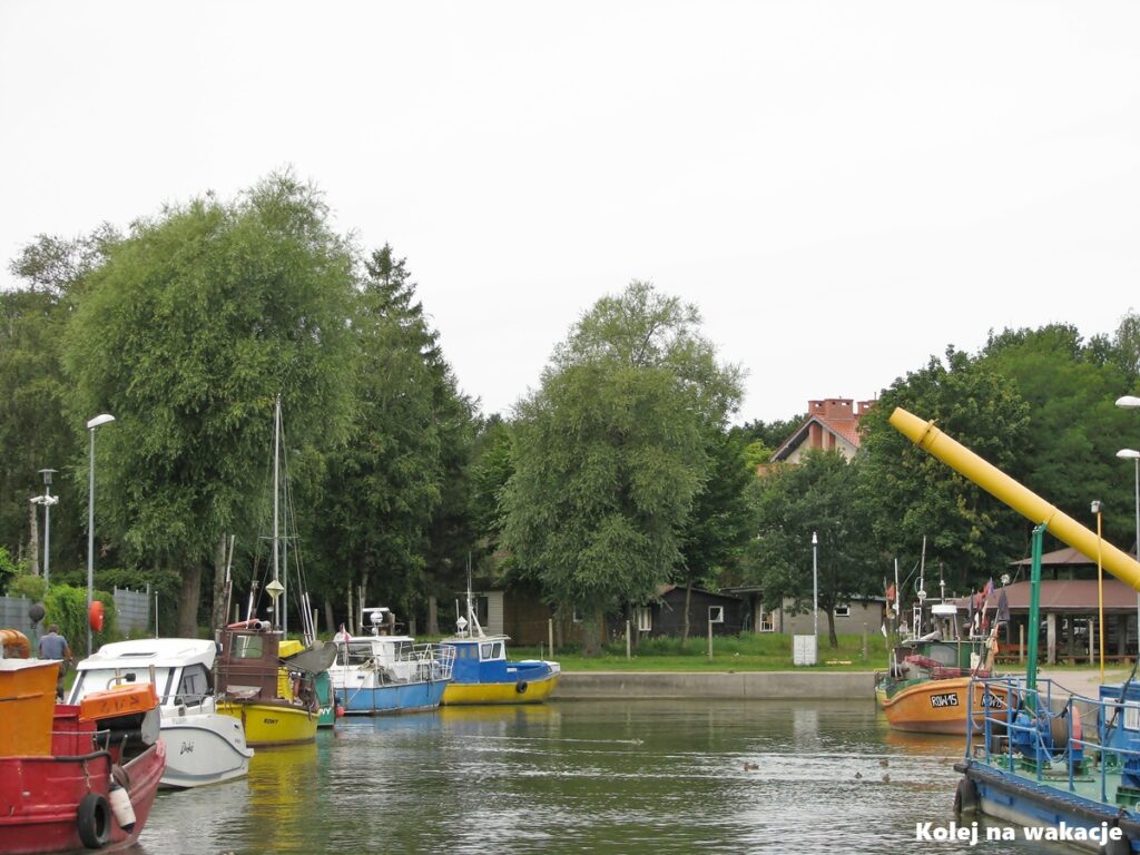 Niewielki port rybacki w Rowach u ujścia rzeki Łupawy do Morza Bałtyckiego, z zacumowanymi łodziami rybackimi.