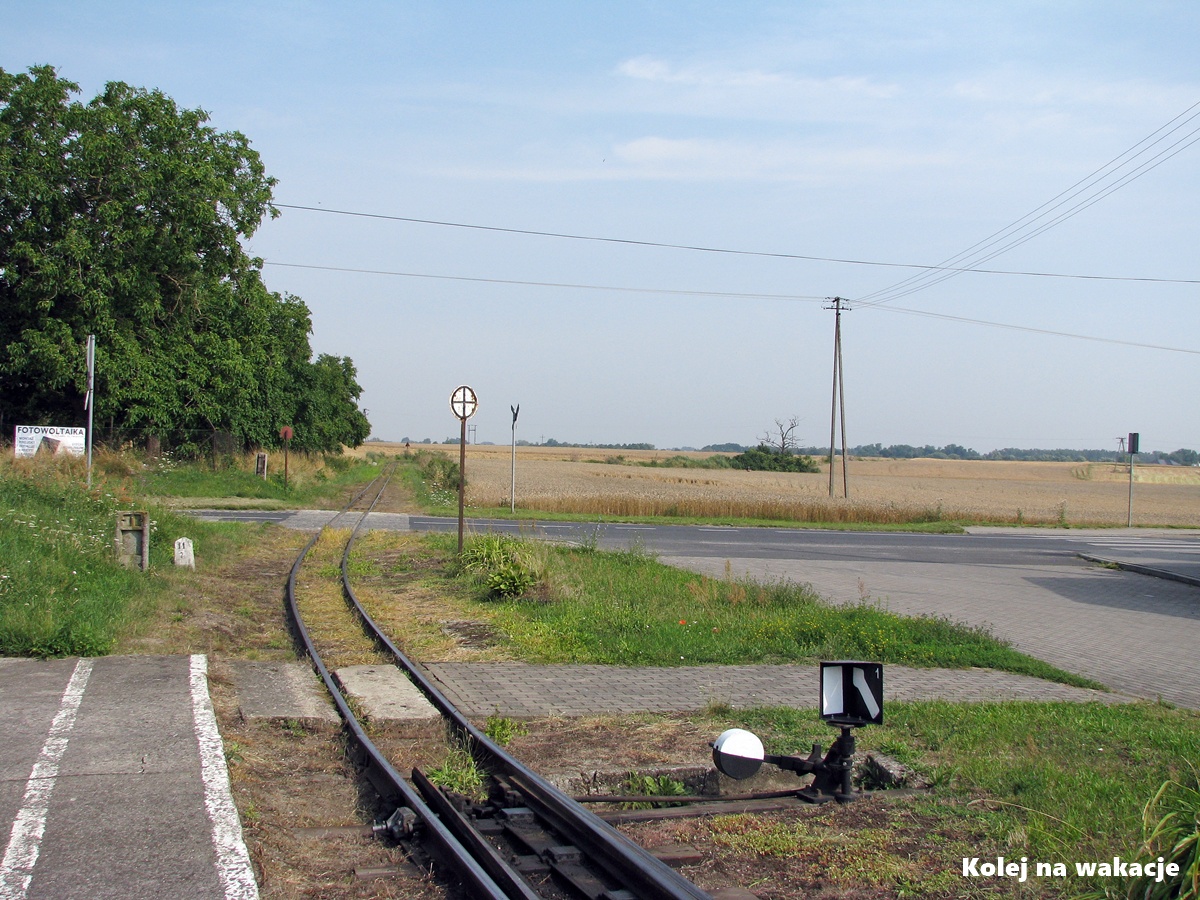 Zabytkowa stacja kolejowa w Gąsawie na trasie Żnińskiej Kolei Powiatowej w słoneczny dzień.
