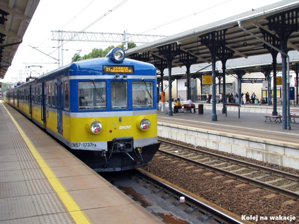 Żółto-niebieski pociąg SKM EN57 na peronie stacji Gdańsk Główny, idealny transport po Trójmieście.