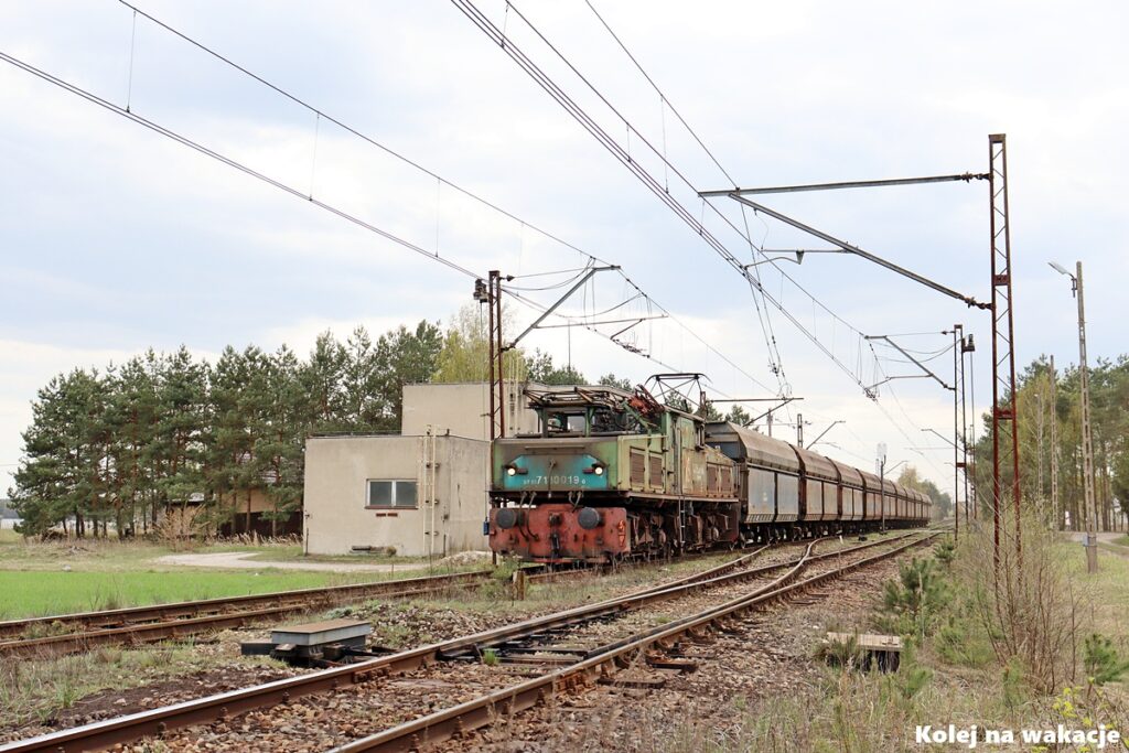 Lokomotywa EL2 nr 19 z pustymi węglarkami mija budynek nastawni w Wygodzie.