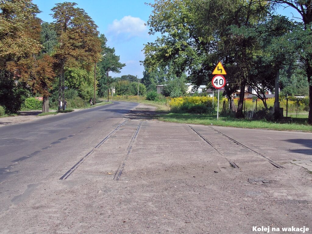 Zlikwidowane i nieczynne torowisko tramwajowe wtopione w asfalt na ulicy Rudzkiej w Łodzi.