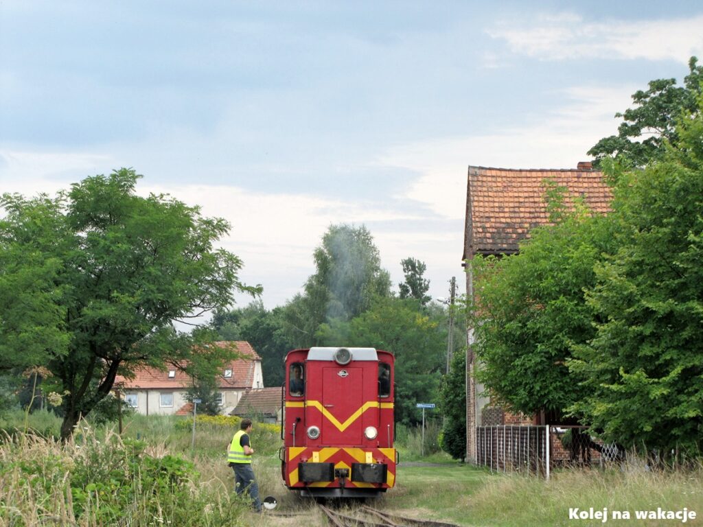 Czerwona lokomotywa spalinowa Lxd2-373 z żółtym pasem wykonująca manewry na stacji w Stanicy, Zabytkowa Stacja Kolei Wąskotorowej w Rudach.