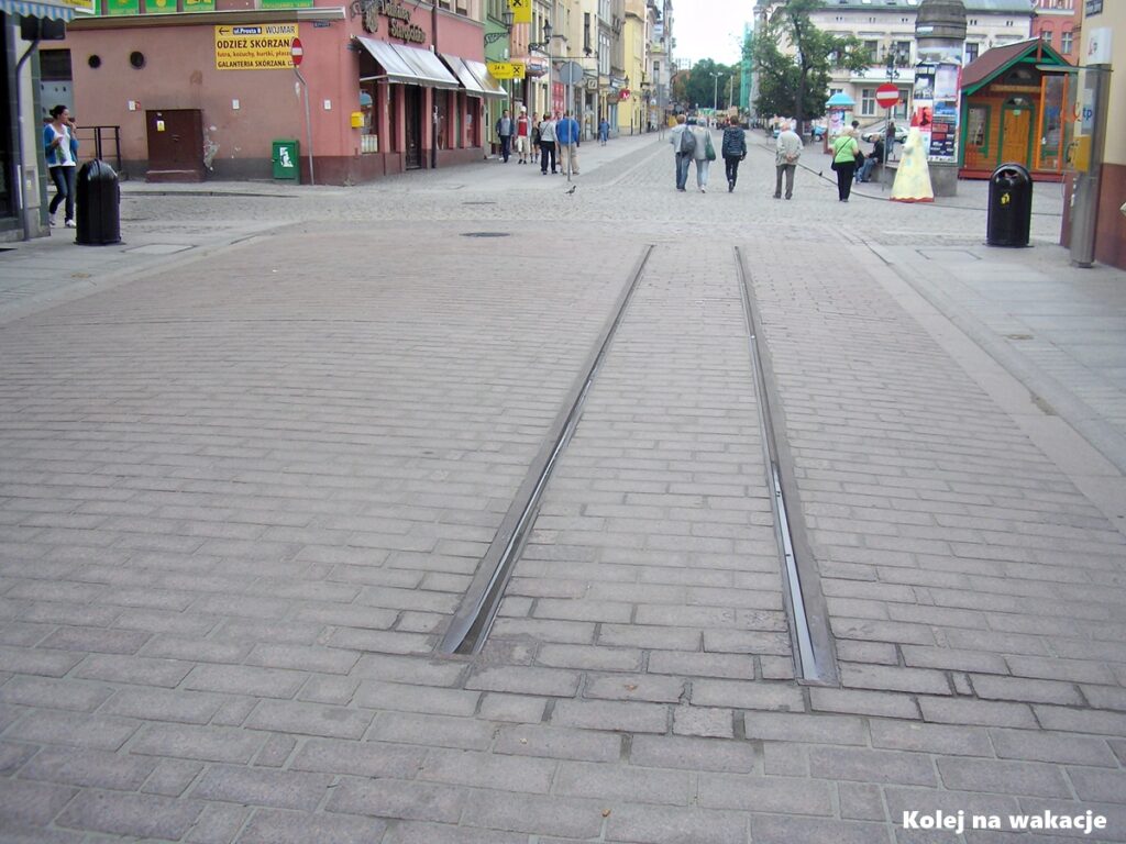 Zachowany fragment dawnego torowiska tramwajowego z kostką brukową na deptaku przy ulicy Królowej Jadwigi w Toruniu.