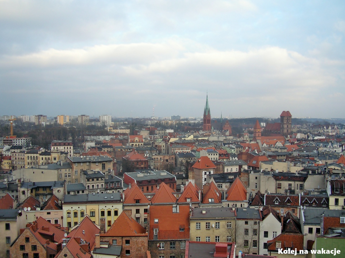 Toruń – sprawdzony plan na weekendową wycieczkę (co zobaczyć + dojazd pociągiem) 2 Panorama zabytkowego centrum Torunia z lotu ptaka, widoczne czerwone dachy gotyckich budowli.