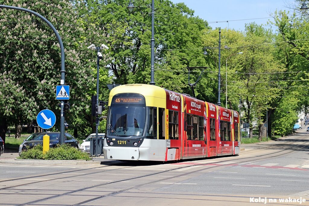 🚋 Jak zwiedzić Łódź tramwajem? Gotowy plan wycieczki po mieście 5 ramwaj podmiejski linii 45 jadący do Zgierza sfotografowany z ostrym liściem kasztanowca na pierwszym planie i rozmytym tłem.